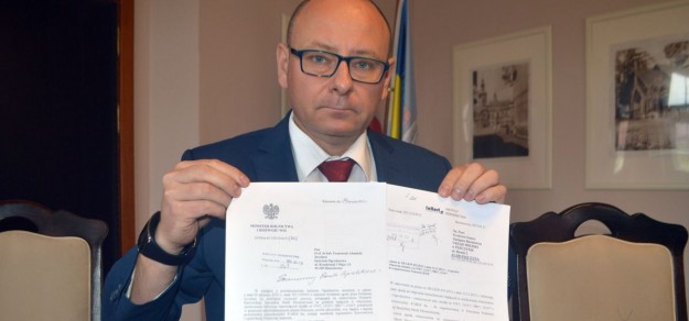 Burmistrz pokazuje pisma, w których mowa jest o zgodzie na utworzenie strefy ekonomicznej przy ul. Wodzisławskiej i Żorskiej.